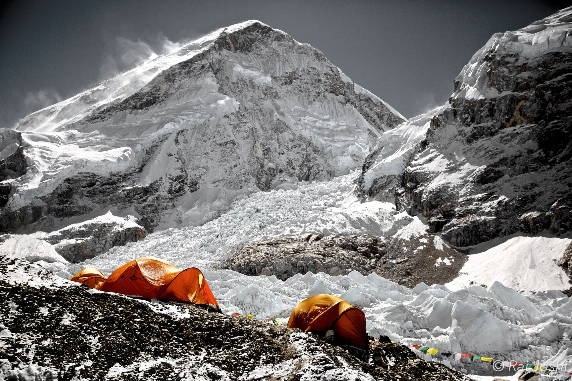 Expedition tents on a glacier beneath the towering snow walls of Everest