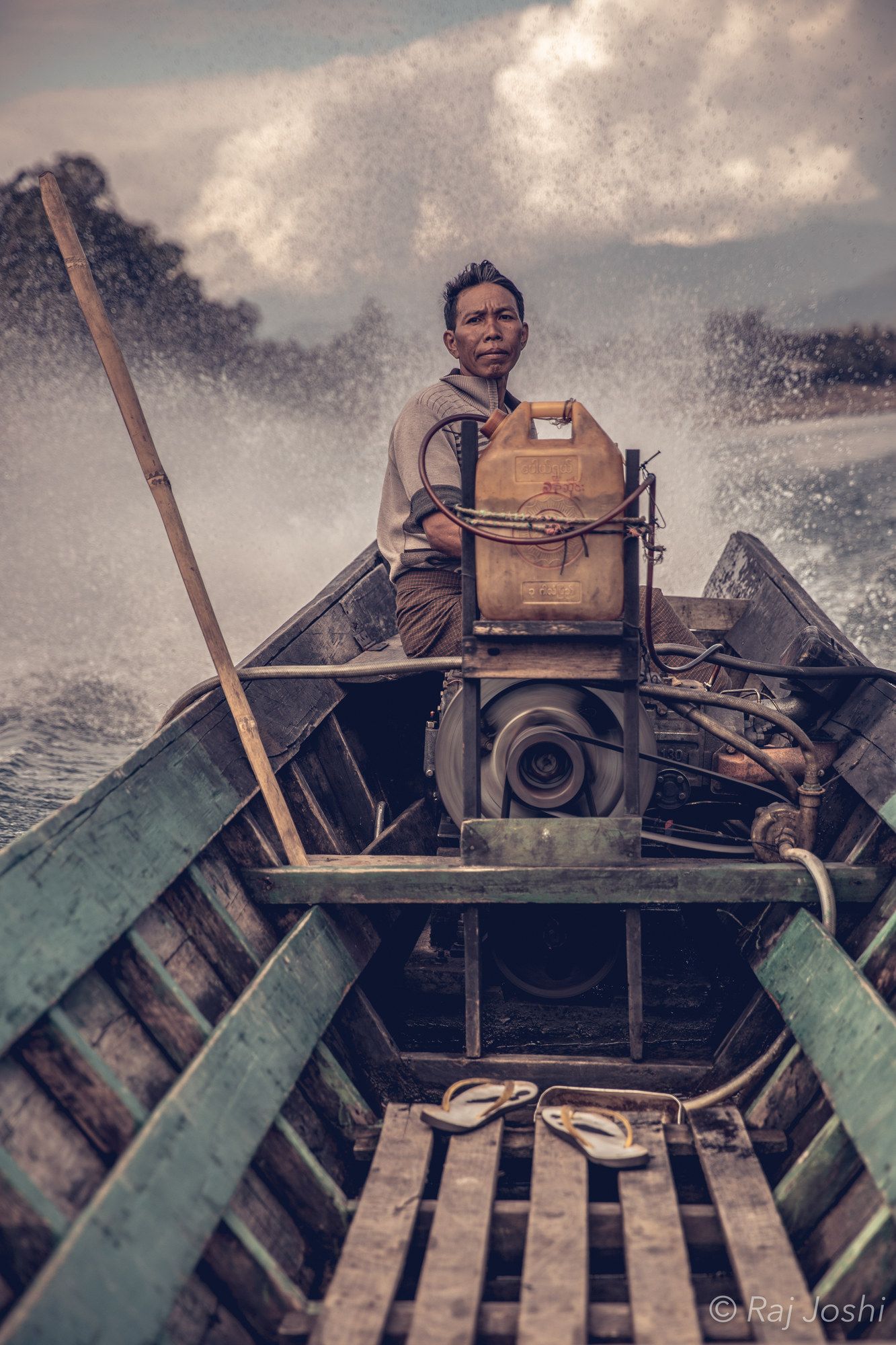 A figure in a narrow wooden boat heading upriver at first light, camera ready
