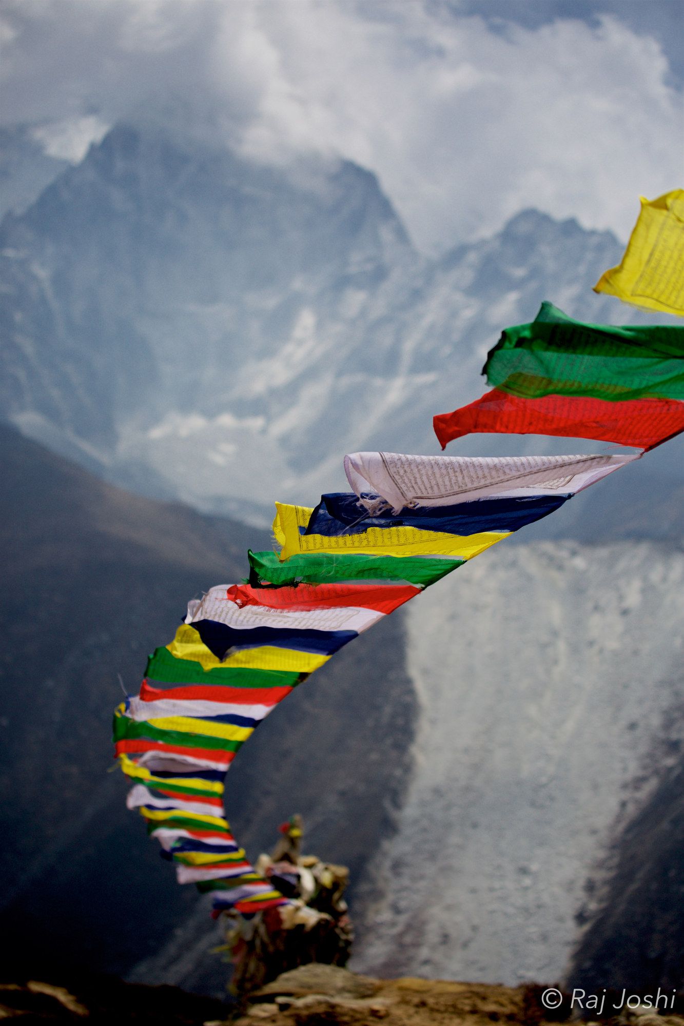 Strings of prayer flags snapping in the wind on a snowbound ridge