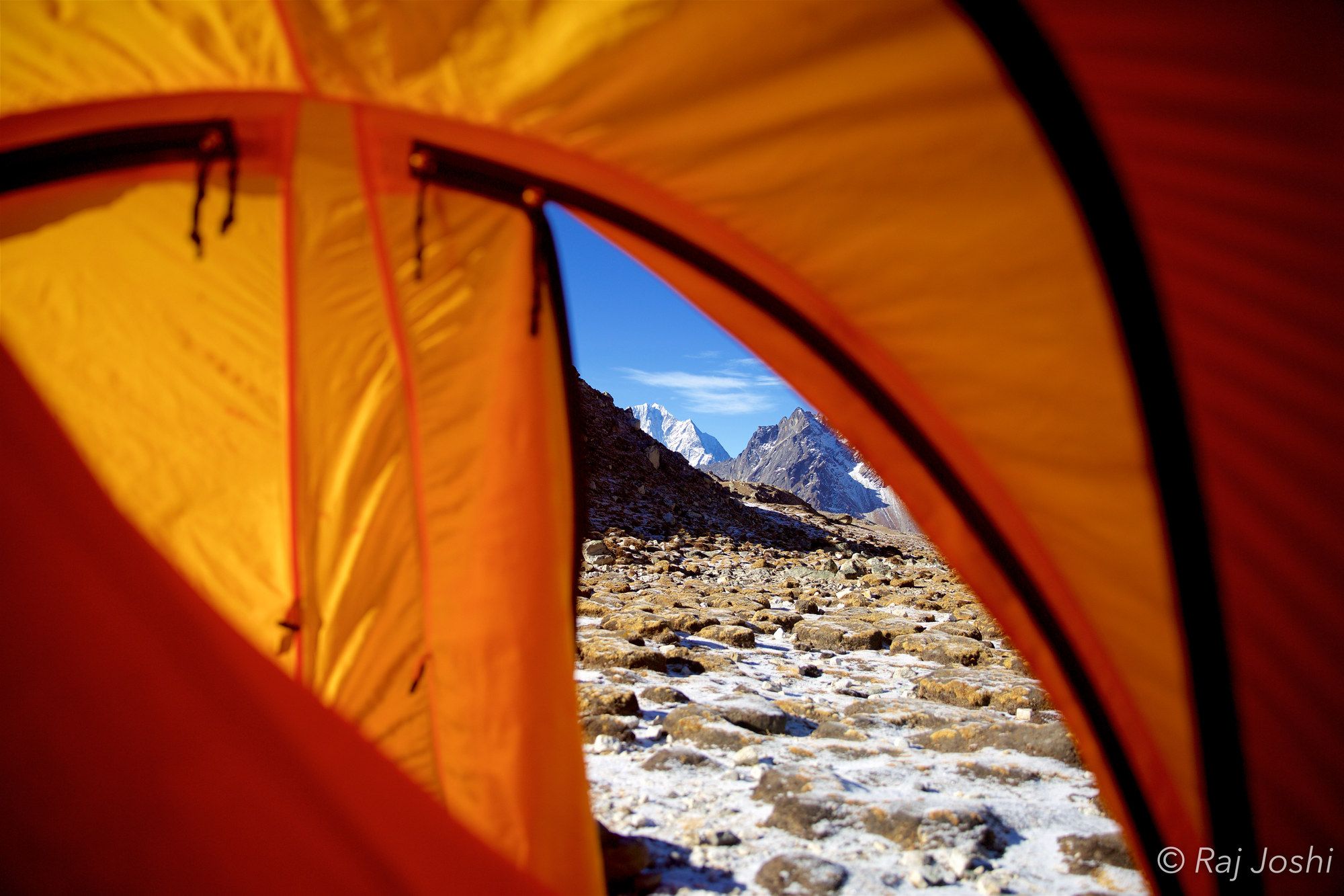 Snow peaks at dawn seen from the door of a high-camp tent