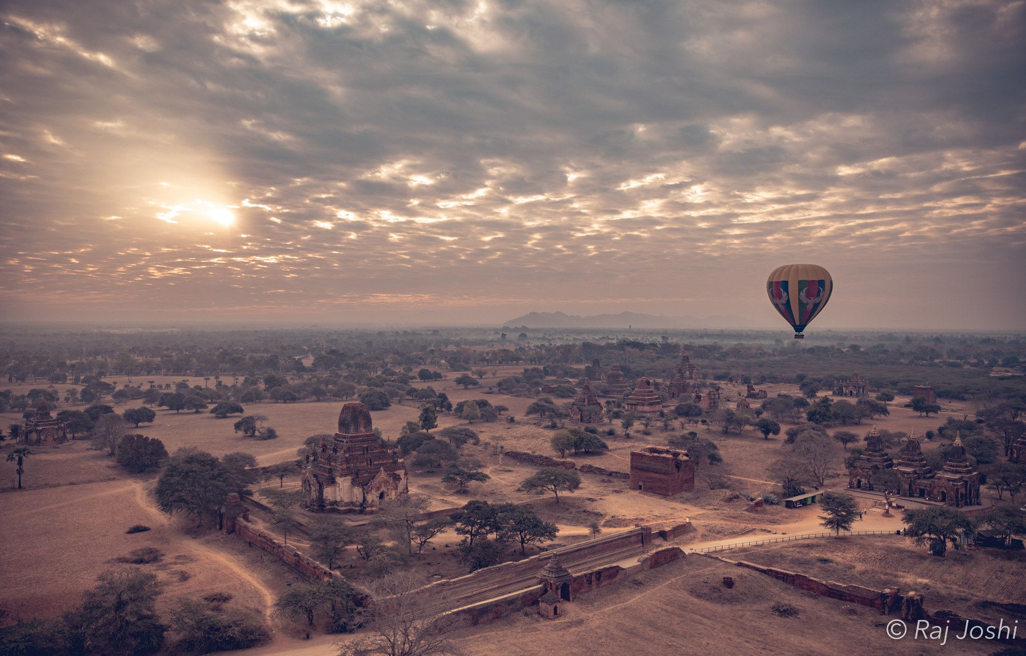 Hot-air balloons drifting over the temple plain of Bagan at sunrise